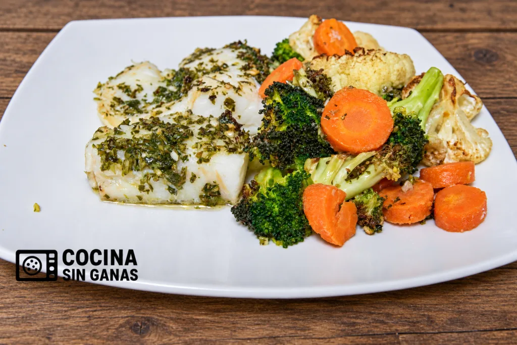 Bacalao con picada de ajo y perejil y verduras asadas hechos en freidora de aire, servidos en plato blanco